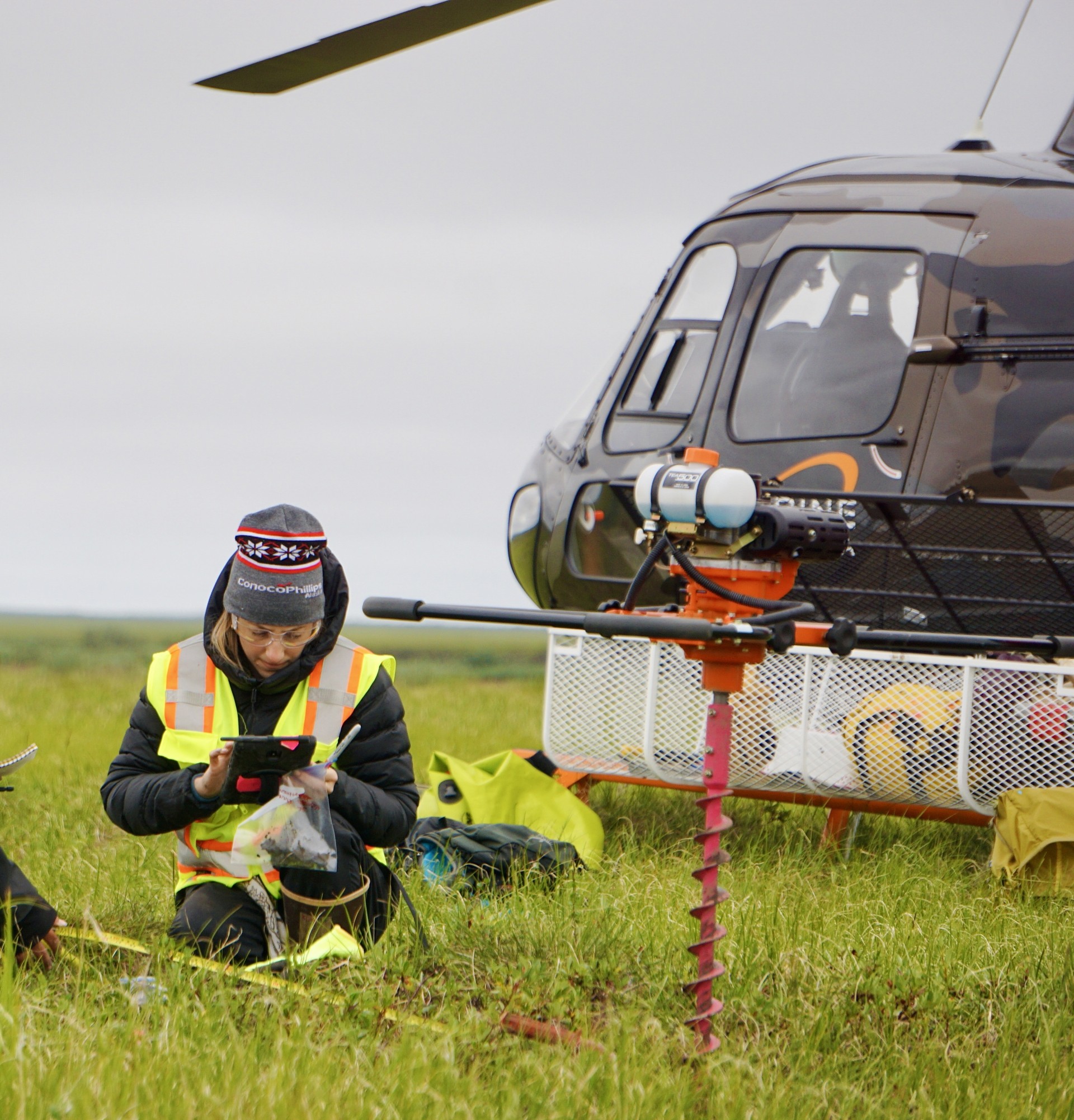 woman kneels next to helicopter